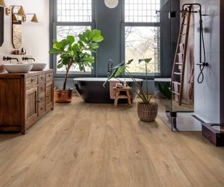 wood flooring in modern bathroom with freestanding bath