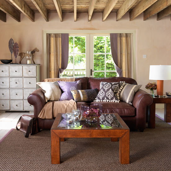 living room with leather sofa and glass coffee table