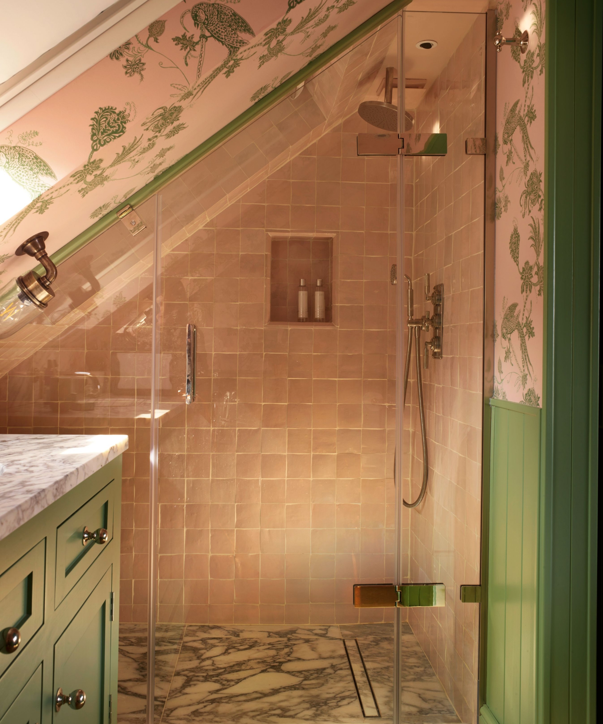 a loft shower room with a slanted ceiling, pink shower tiles, marble floor tiles, and a recessed niche in the shower wall for storage