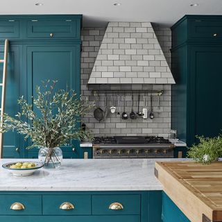 kitchen with marble worktop and metro tiles with plant on jar