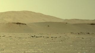 NASA's Mars helicopter Ingenuity takes its third flight on the Red Planet in this zoomed-in view of a photo from the Perseverance rover taken on April 25, 2021.