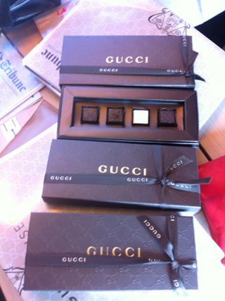 wrapped copies of the International Herald Tribune and embossed boxes of Gucci chocolates