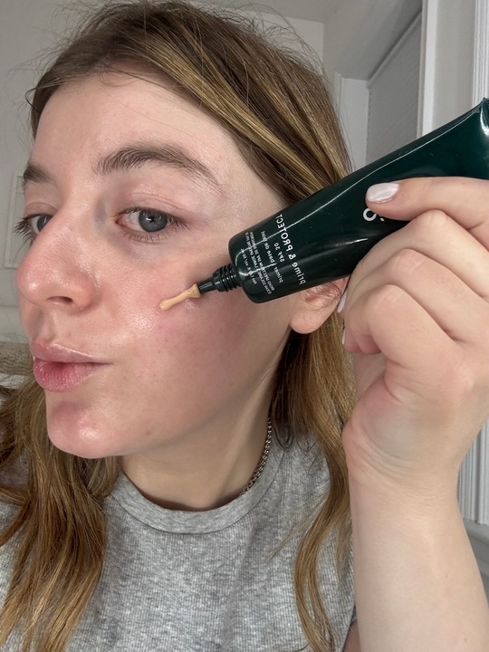 a girl with a gray shirt and blonde hair before applying spf.