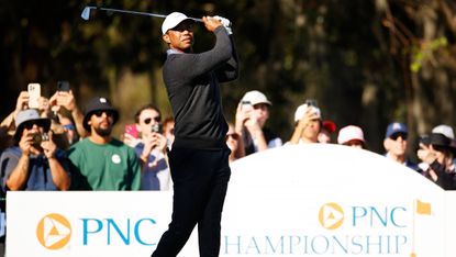 Tiger Woods takes a tee shot in a pro-am ahead of the PNC Championship