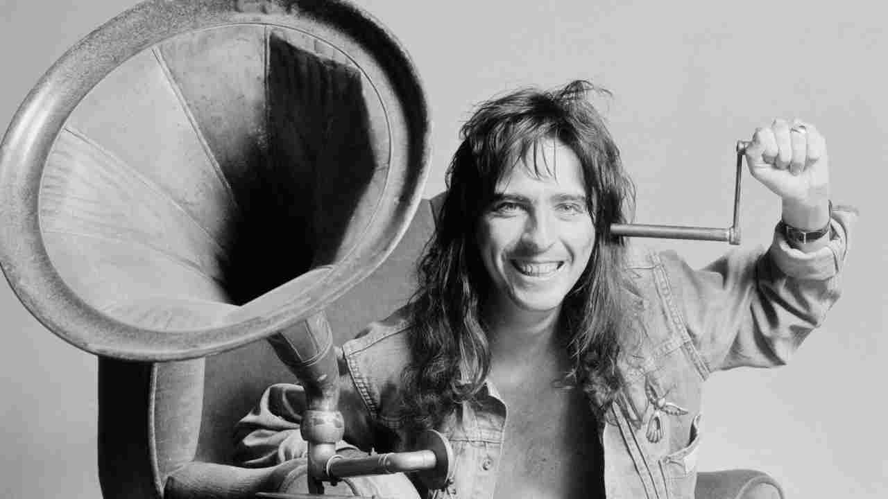 Alice Cooper posing with a giant gramophone speaker in 1974