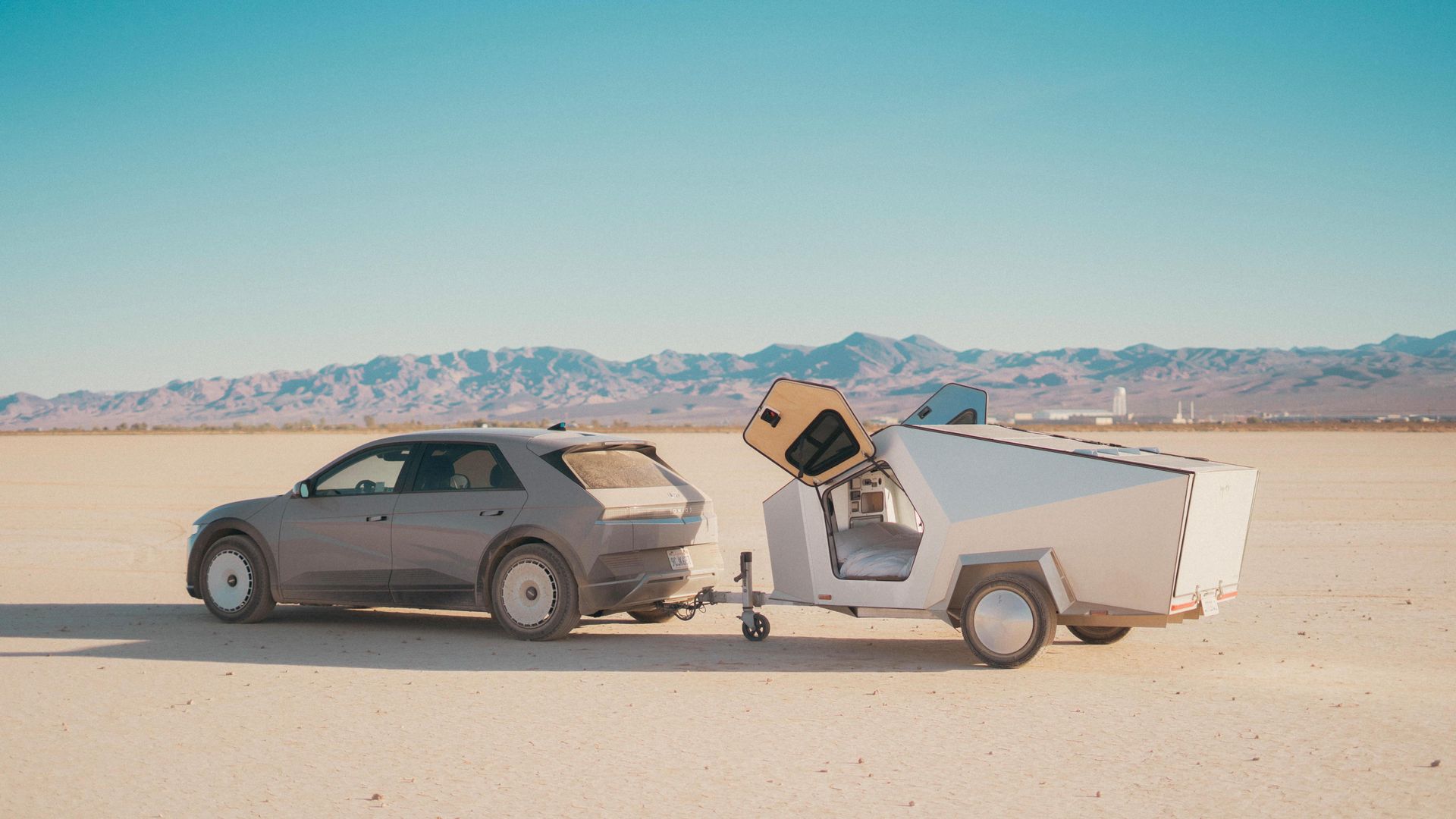 Polydrops P17A1 All Electric trailer being towed by electric car across desert landscape