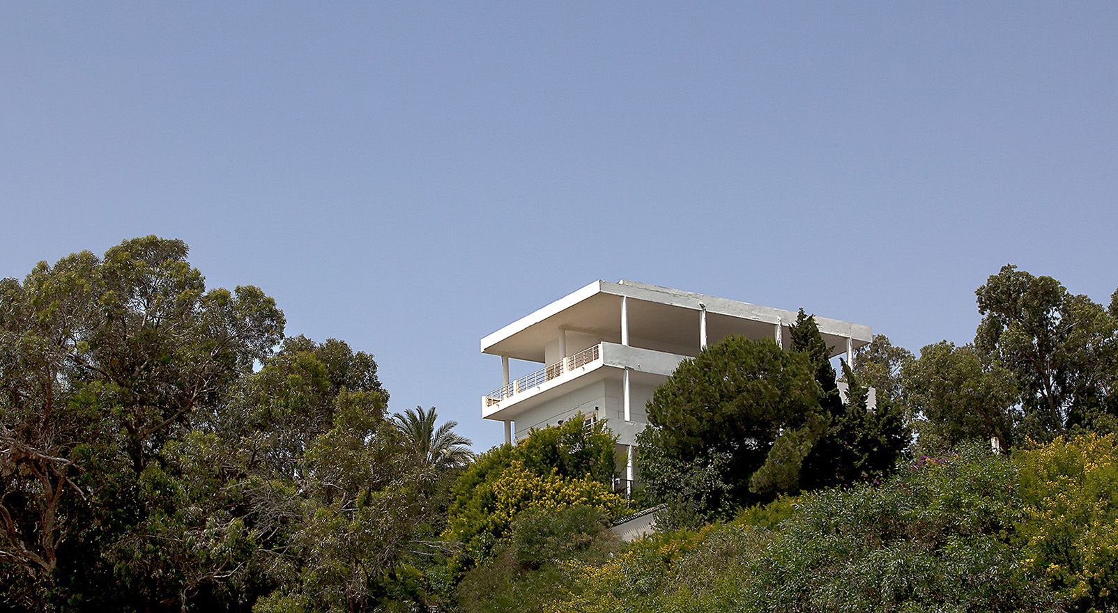 white villa on wooded hilltop