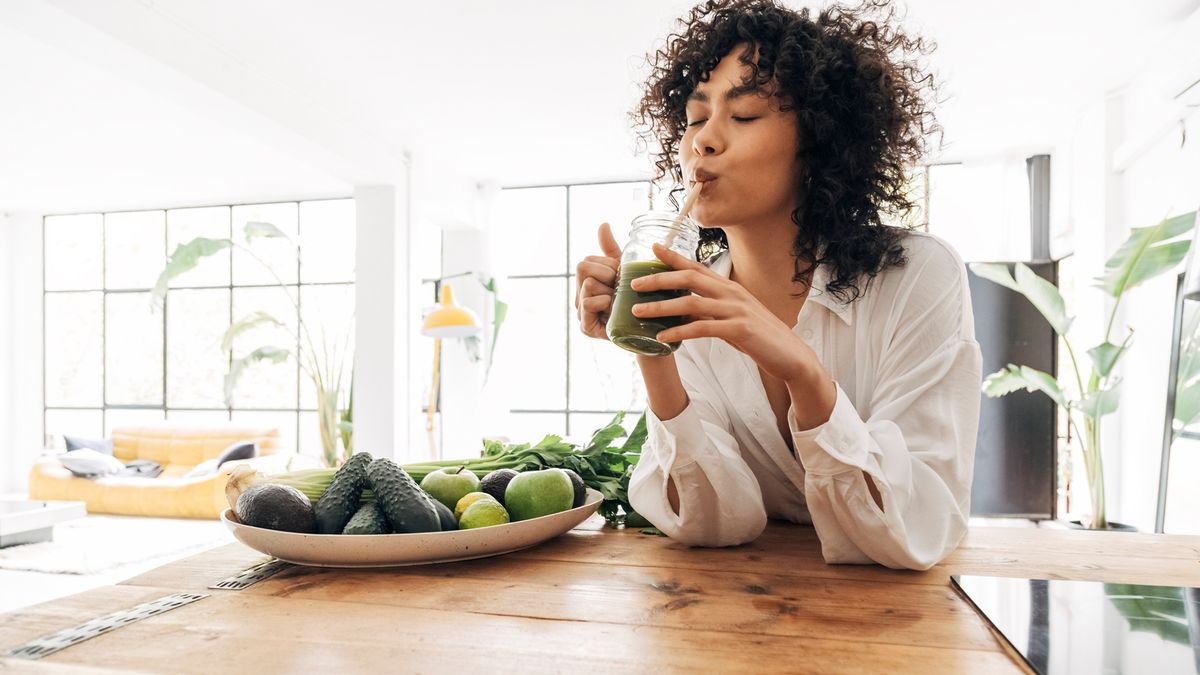 woman drinking a green juice