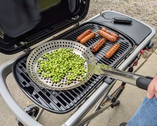 edamame and sausages being cooked on the Weber Traveler Gas Grill in writer's home