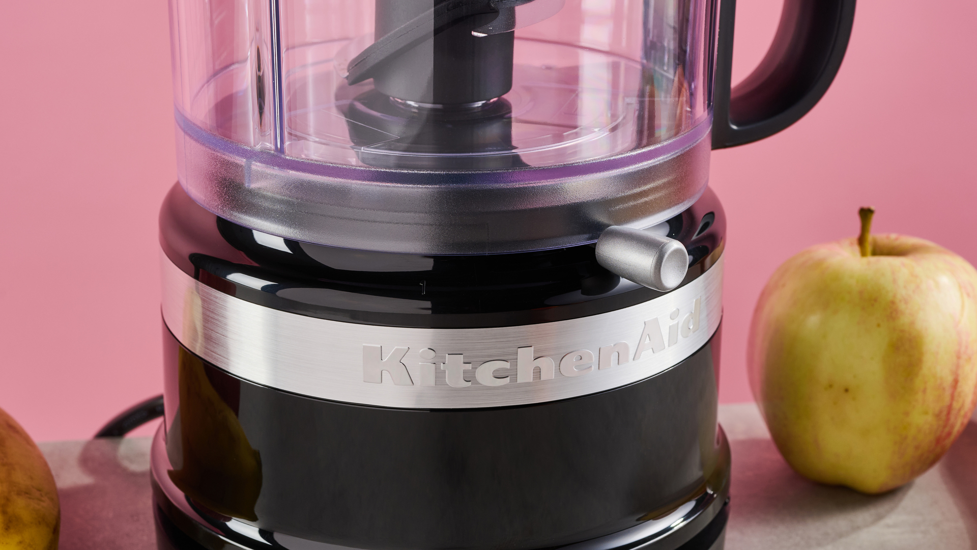 A close up of the base of the KitchenAid Mini Food Chopper in gloss Onyx Black, showing the control lever.