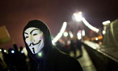 A masked Occupy Wall Street protester walks across the Brooklyn Bridge Thursday night: Hundreds of Occupiers were arrested during the two-month-old movement's "Day of Action."
