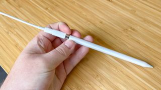 The first-generation Apple Pencil charging via a Lightning cable and an adapter