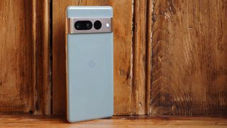 Google Pixel 7 Pro finished in Hazel standing upright against a wooden background