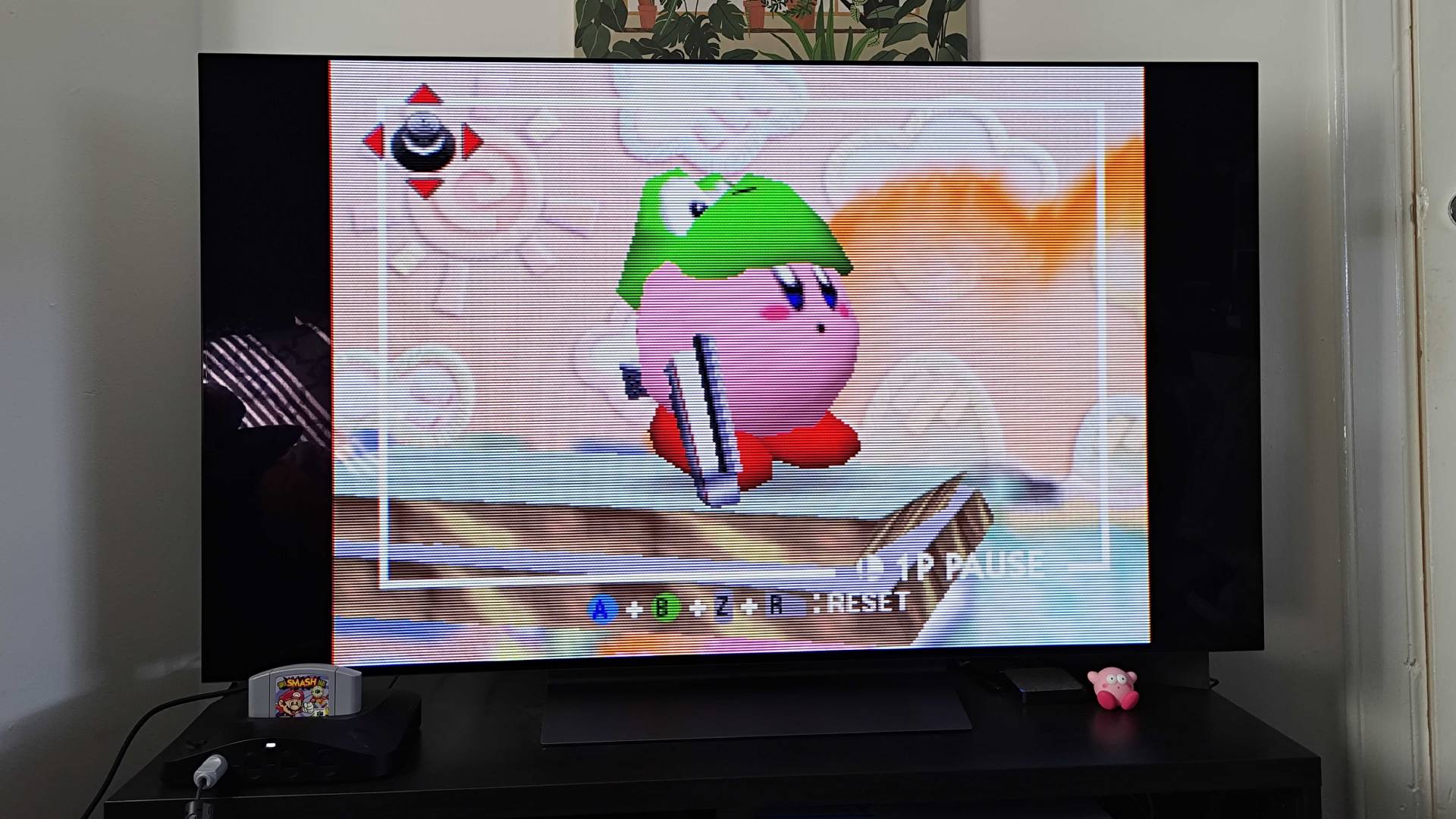Analogue 3D connected to LG OLED TV with Super Smash Bros gameplay on screen featuring Kirby with gun and Yoshi hat.