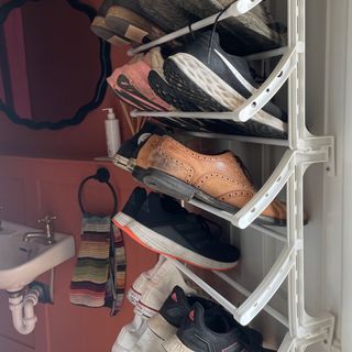 white over door shoe rack stacked with shoes on a white door with terracotta room behind