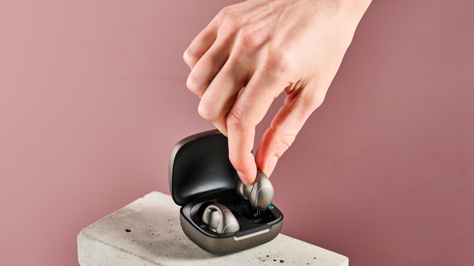 Someone picking Anker Soundcore C40i out of charging case