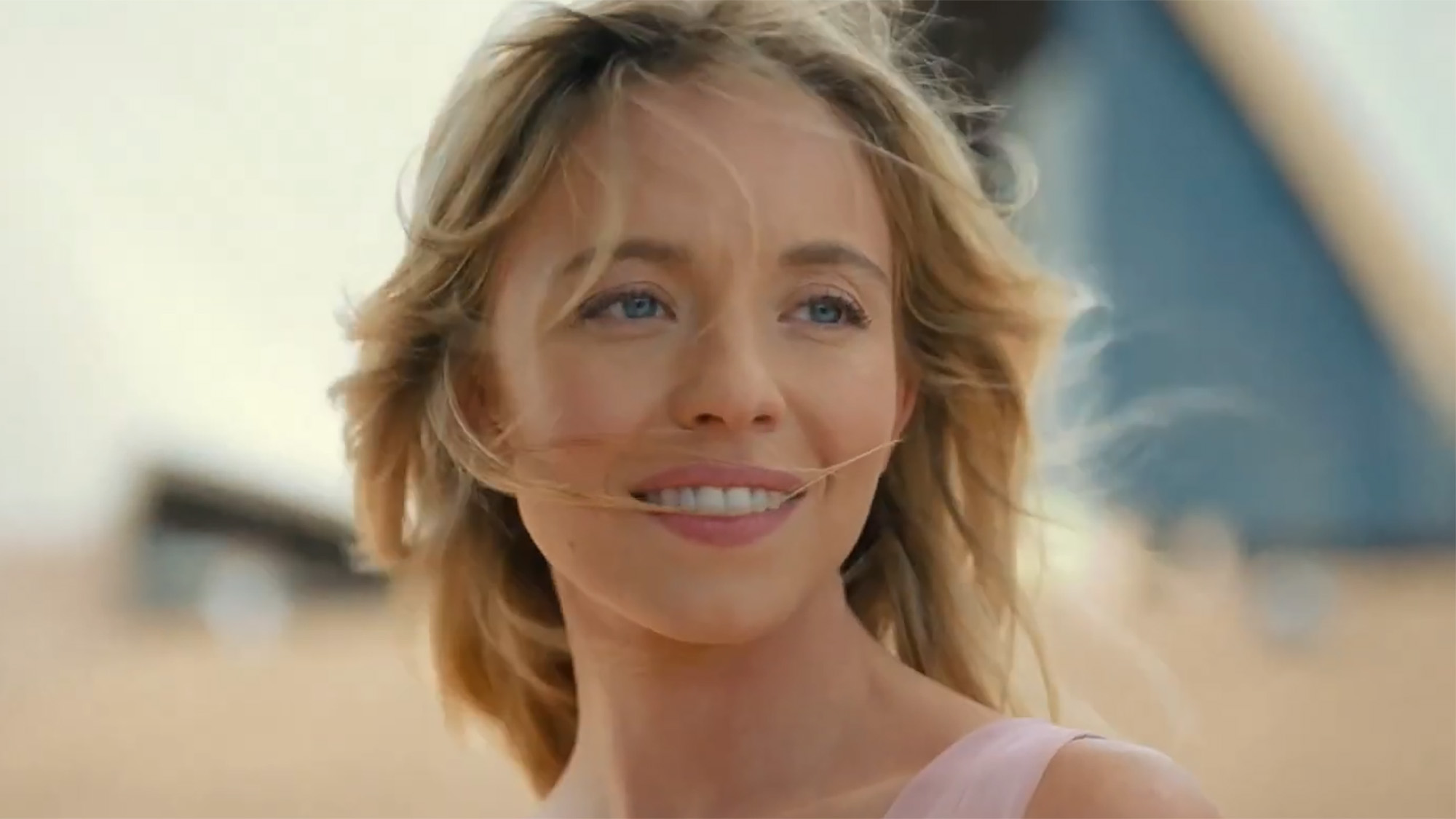 Sydney Sweeney with her hair blowing in the wind outside Sydney opera house, AU. 