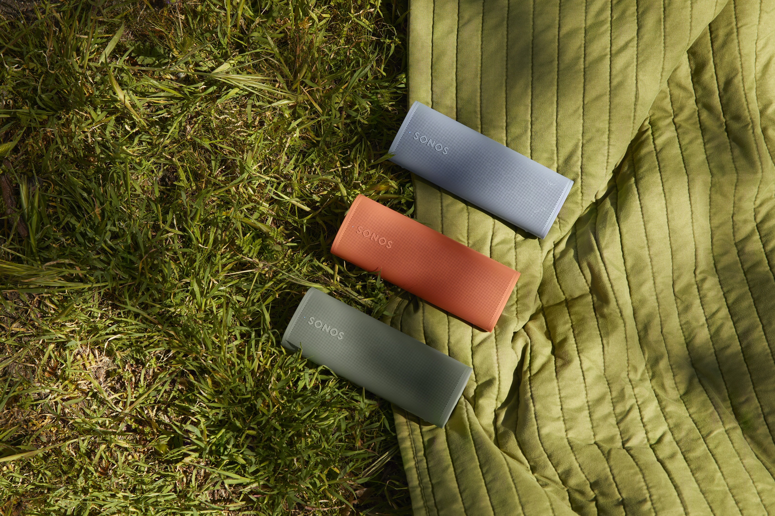 Sonos roam 2 speakers on a blanket in a park