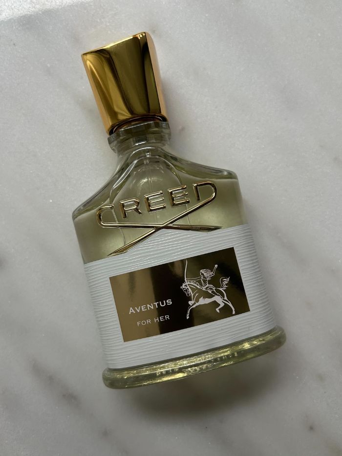 A picture of a Creed perfume on a marble background