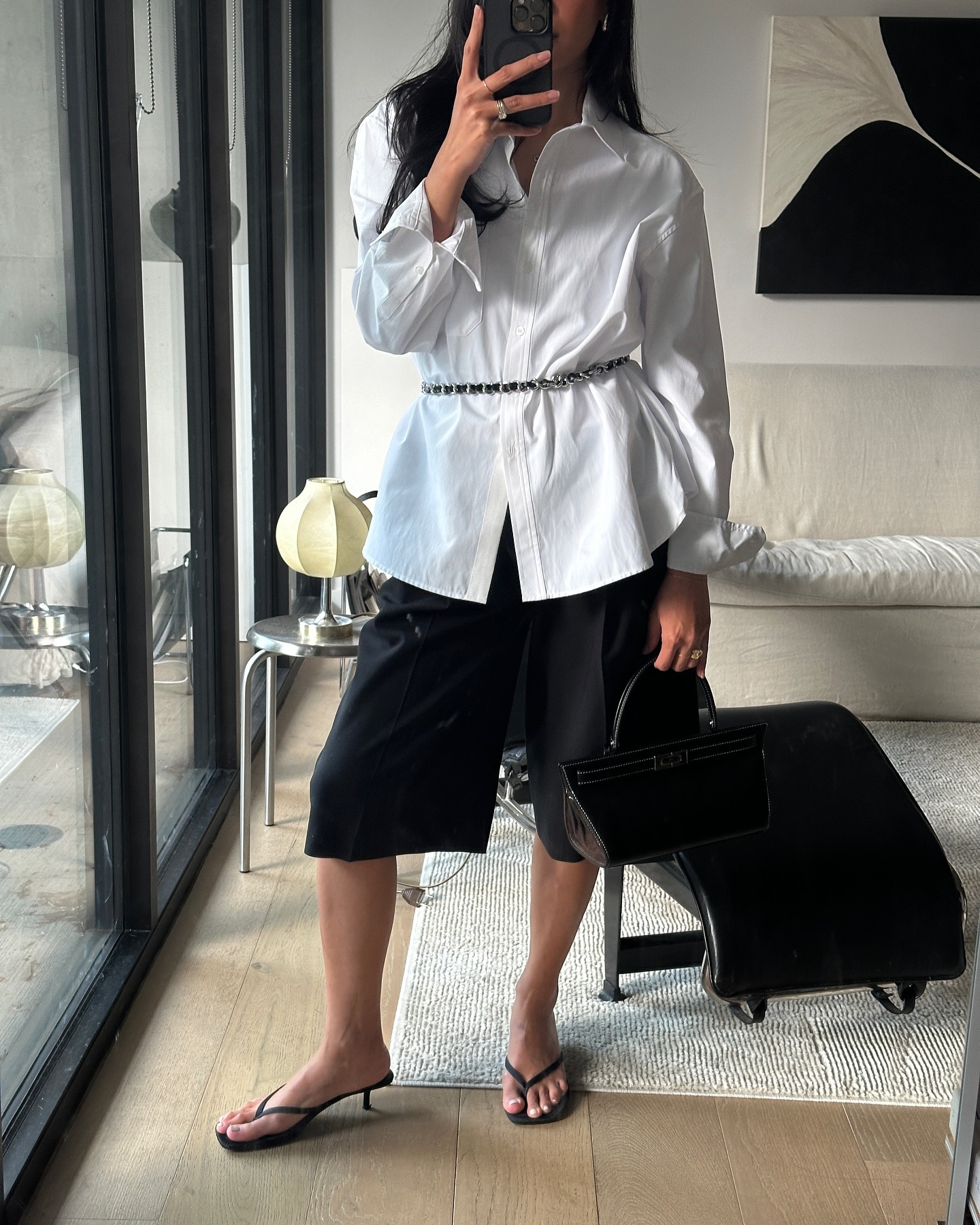 @dawn.tan wears a black tailored Bermuda shorts with heeled flip flops
