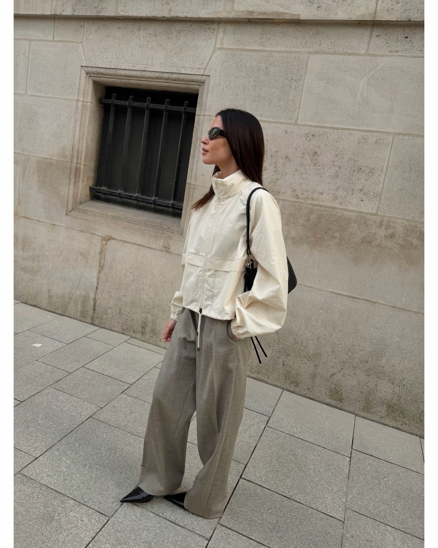Johanna wears a windbreaker and trousers.
