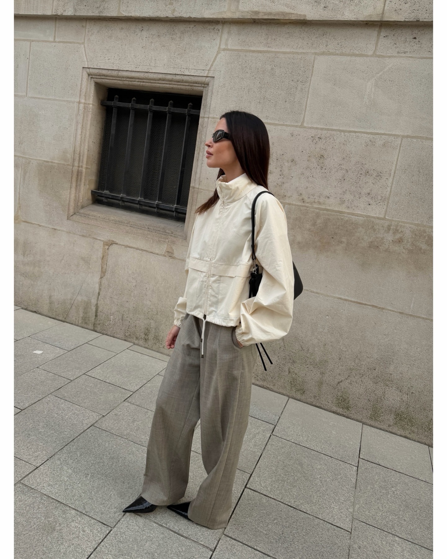 Johanna wears a windbreaker and trousers.