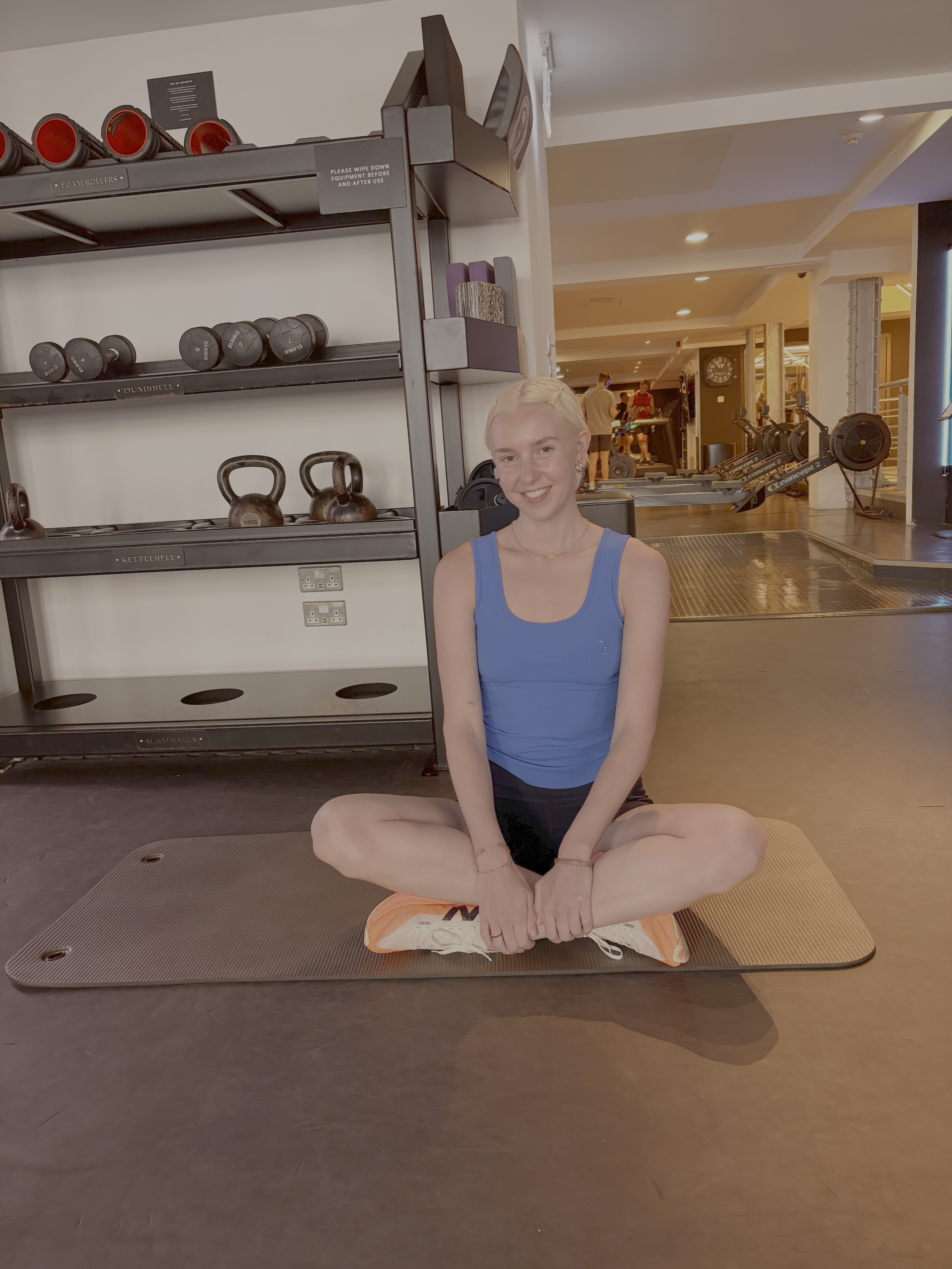A woman sitting cross legged in a gym