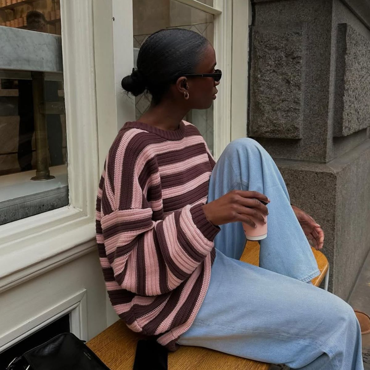 Live Madeline wears a pink and burgundy stripe jumper with blue jeans