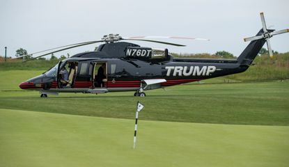 Trump's helicopter parked behind a golf green