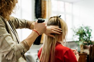 Hair extensions being fitted in hairdresser