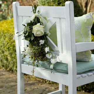 white chair with cushion and flowers