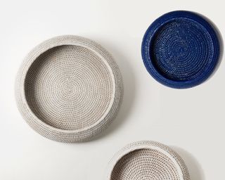A series of white and deep blue rattan bowls on a white background