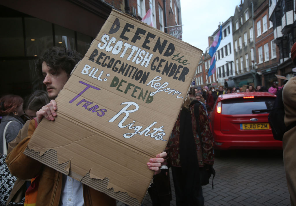 Un manifestant à Cambridge brandit une pancarte disant 