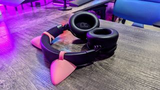 The Razer Kraken V4 Pro lying on a desk with its earcups facing up, highlighting the large "R" inside one.