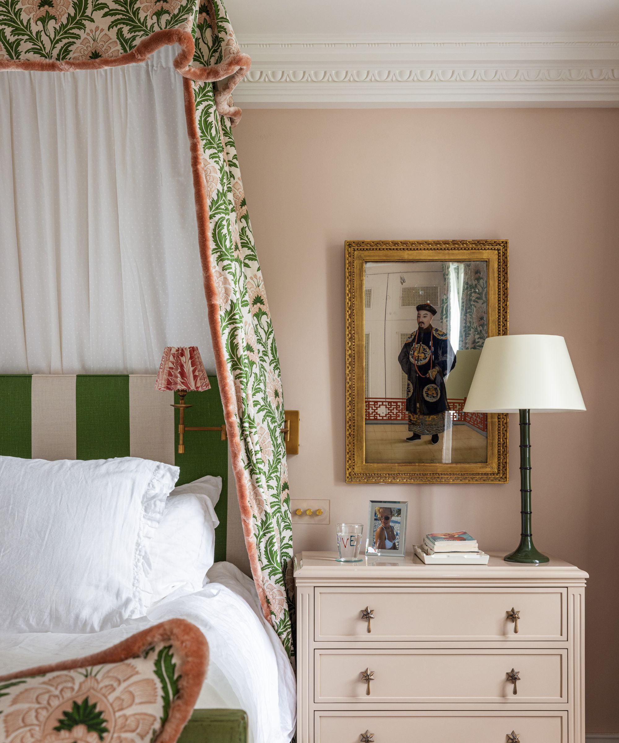 pink and green bedroom with patterned fabric bed canopy