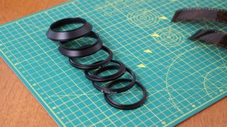 Adapter rings for a JJC Film Digitizing Adapter Set lined up on a green lined cutting mat