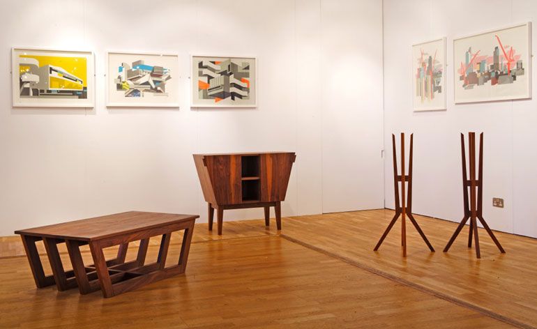 Dark wooden furniture on wooden floor and frames on the wall