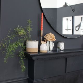 Detail of a black fireplace on a wall painted in Farrow & Ball's Railings