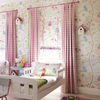 bedroom with batty wallpaper bed and pink curtains