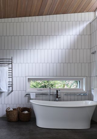 A bathroom with white tiles and black grout