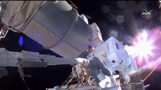 NASA astronaut Kate Rubins' glove is pictured in the foreground of this view of JAXA astronaut Soichi Noguchi, captured from Rubins' helmet camera during a spacewalk on March 5, 2021.