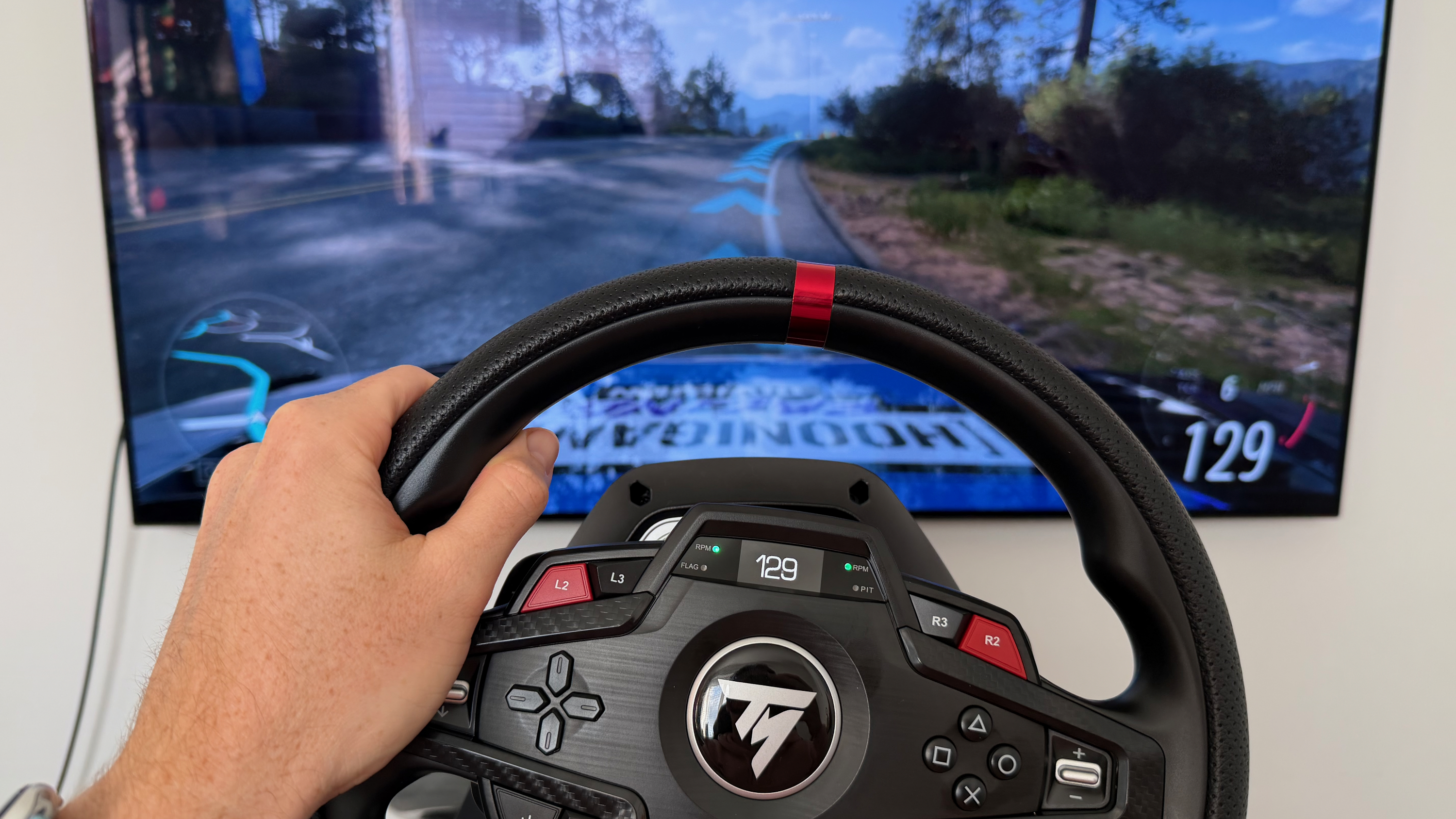 A reviewer holding the left hand side of the Thrustmaster T248R while playing Forza Horizon 5