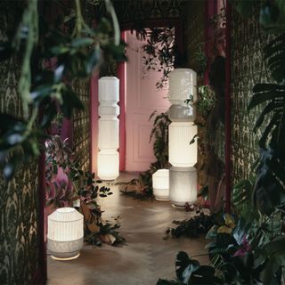 Ikea table and floor lamps in passage with plants