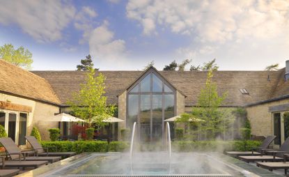 Exterior of Calcot Manor, Gloucestershire, UK with jacuzzi and sun loungers