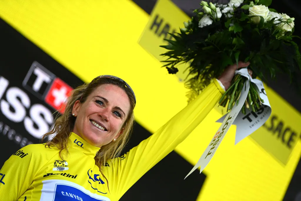 Annameik van Vleuten in the Maillot Jaune holding up some flowers.