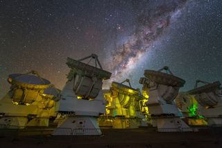The central region of the Milky Way can be seen above the antennas of the ALMA observatory in Chile.
