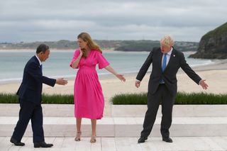 Carrie Johnson, wife of U.K. prime minister, center, and Boris Johnson, U.K. prime minister, right, gesture to Japan's prime minister Yoshihide Suga, left, on the first day of the Group of Seven leaders summit in Carbis Bay, U.K.