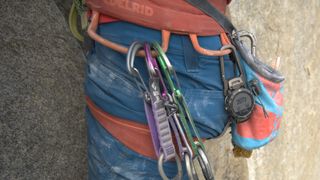 Man rock climbing with Coros Vertix 2 attached to a carabiner