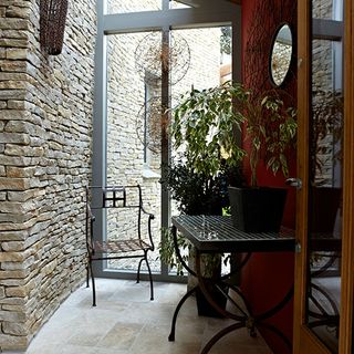 room with rock wall and table with plant pot
