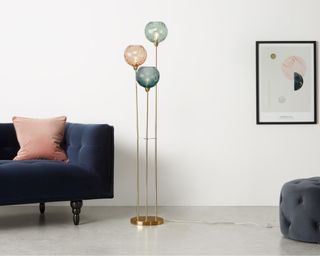 Ilaria Floor Lamp Triple in living room between footstall and sofa